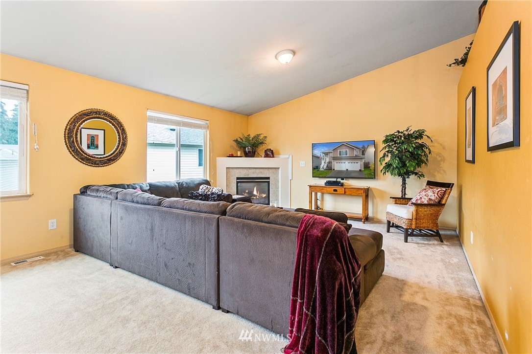 19010 4th Avenue Southeast Bothell, WA 98012 - Photo 4 of 20 a living room with furniture a flat screen tv and a wall clock