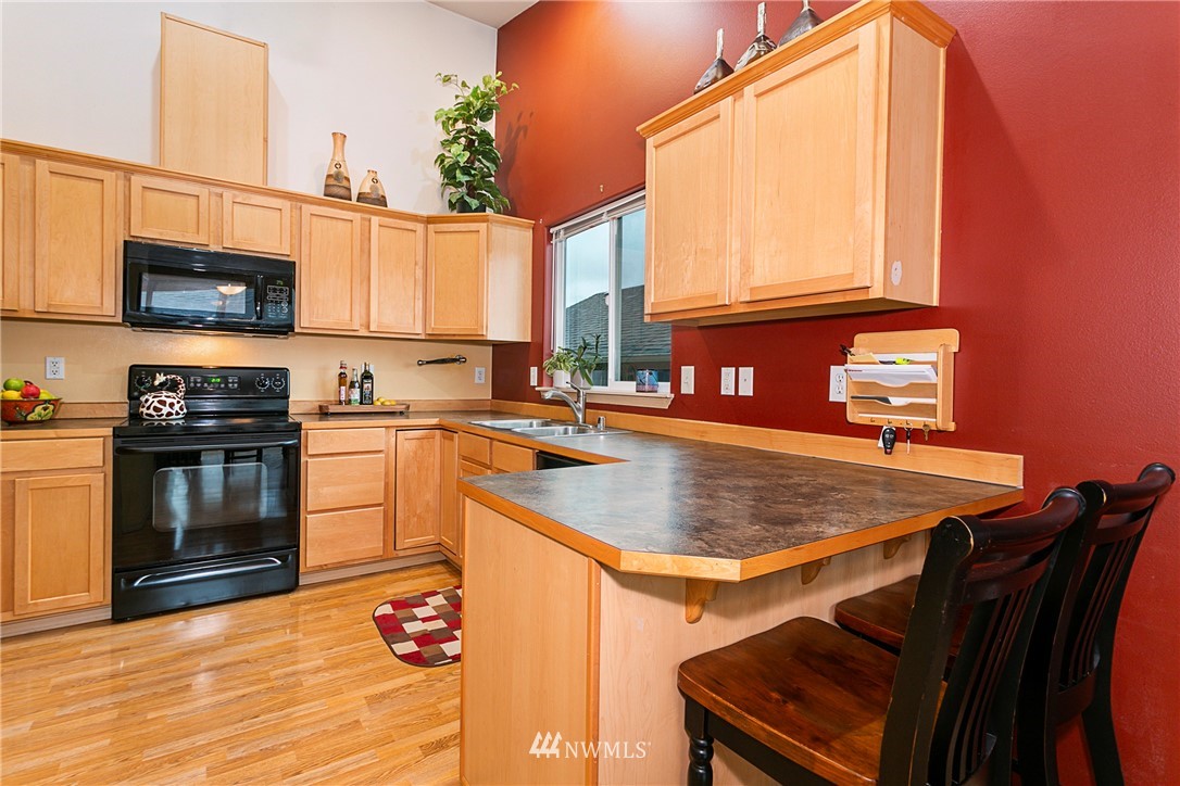 19010 4th Avenue Southeast Bothell, WA 98012 - Photo 6 of 20 a kitchen with stainless steel appliances granite countertop a sink dishwasher stove and microwave