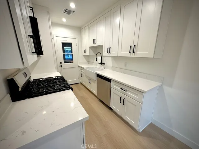 a large white kitchen with sink stove and refrigerator