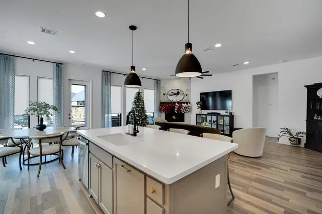 a kitchen with stainless steel appliances a kitchen island a stove a table and chairs