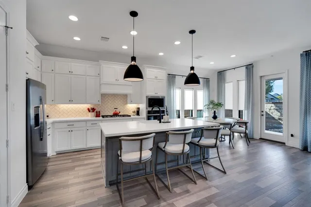 a kitchen with kitchen island wooden cabinets and refrigerator