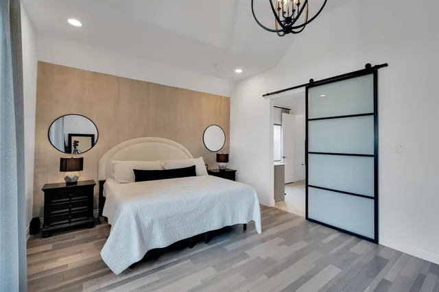 a bedroom with a bed a dresser and with potted plants