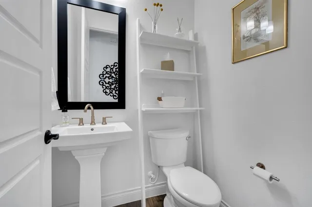 a bathroom with a toilet a sink and mirror