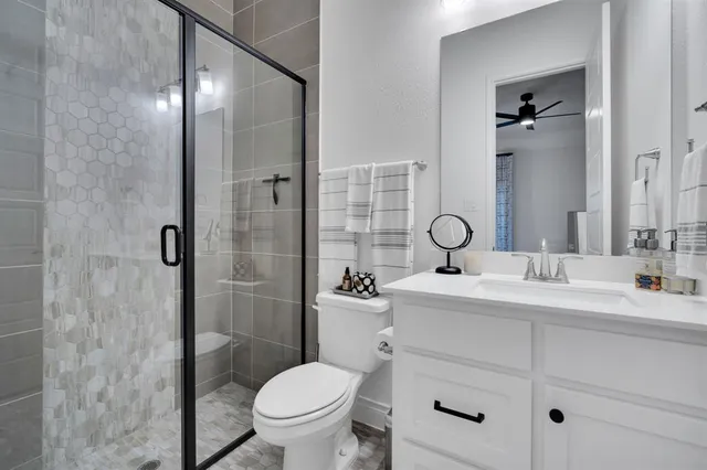 a bathroom with a sink toilet vanity and shower