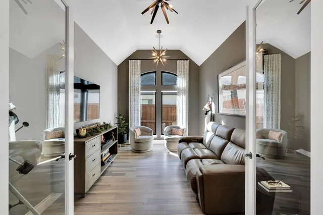 a living room with furniture a large window and wooden floor