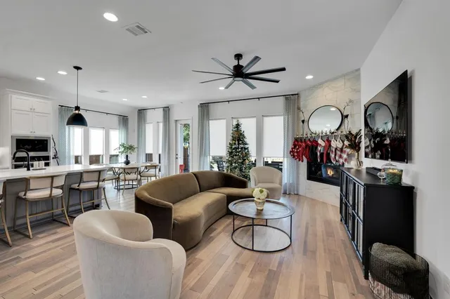 a living room with furniture a flat screen tv and kitchen view
