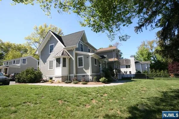 a front view of a house with a yard porch and tree