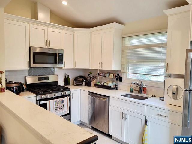 296 County Road, Unit 1 Tenafly, NJ 07670 - Photo 8 of 16 a kitchen with a sink a stove and cabinets