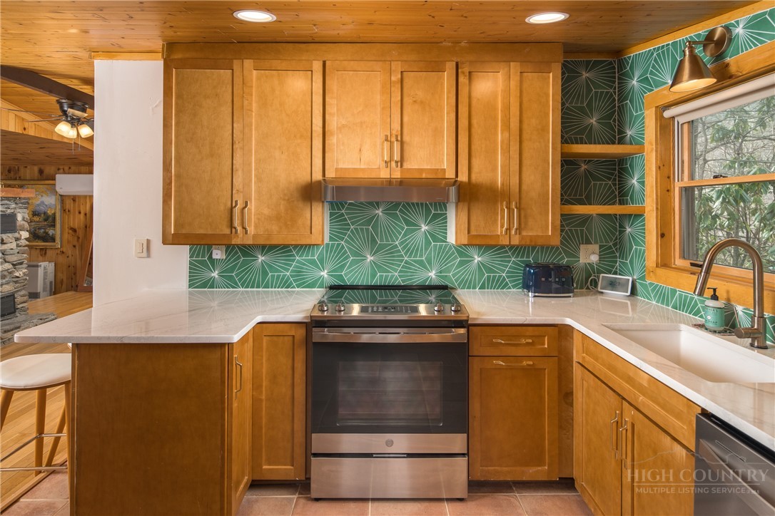 280 Chinkapin Ridge Road Seven Devils, NC 28604 - Photo 12 of 40 a kitchen with stainless steel appliances granite countertop a sink a stove and a microwave