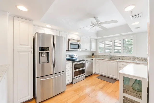 a kitchen with stainless steel appliances a refrigerator sink and microwave
