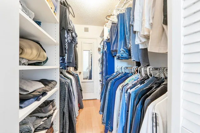 a view of walk in closet with clothes and shoes