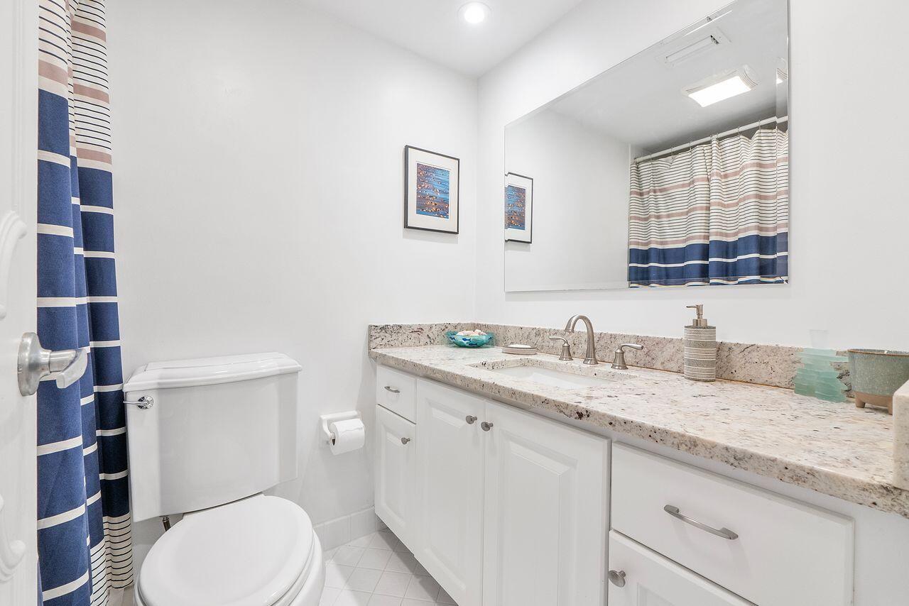 3310 South Ocean Boulevard, Unit 231D Highland Beach, FL 33487 - Photo 20 of 31 a bathroom with a granite countertop toilet sink and mirror