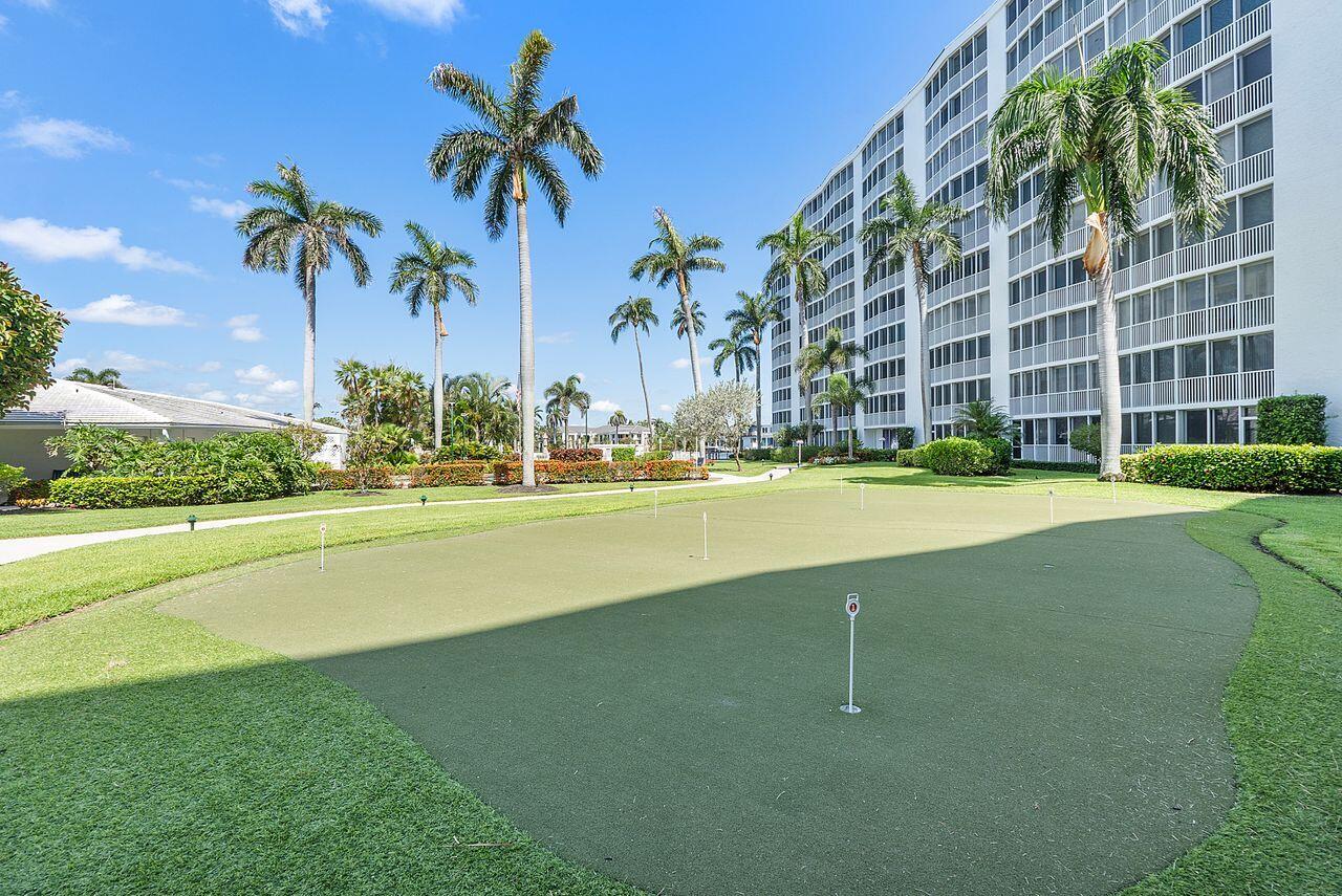 3310 South Ocean Boulevard, Unit 231D Highland Beach, FL 33487 - Photo 27 of 31 a view of a swimming pool with a yard and palm trees