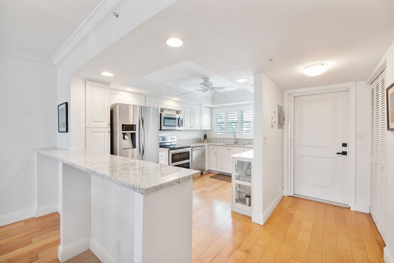 3310 South Ocean Boulevard, Unit 231D Highland Beach, FL 33487 - Photo 3 of 31 a open kitchen with white cabinets and stainless steel appliances