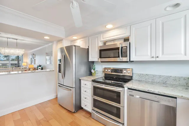 a kitchen with stainless steel appliances white cabinets and a refrigerator