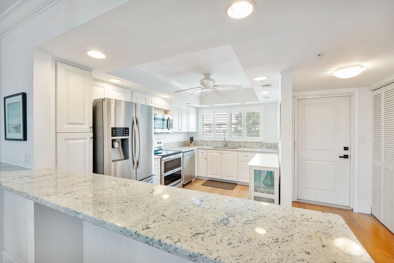 3310 South Ocean Boulevard, Unit 231D Highland Beach, FL 33487 - Photo 6 of 31 a kitchen with stainless steel appliances kitchen island granite countertop a refrigerator and a sink