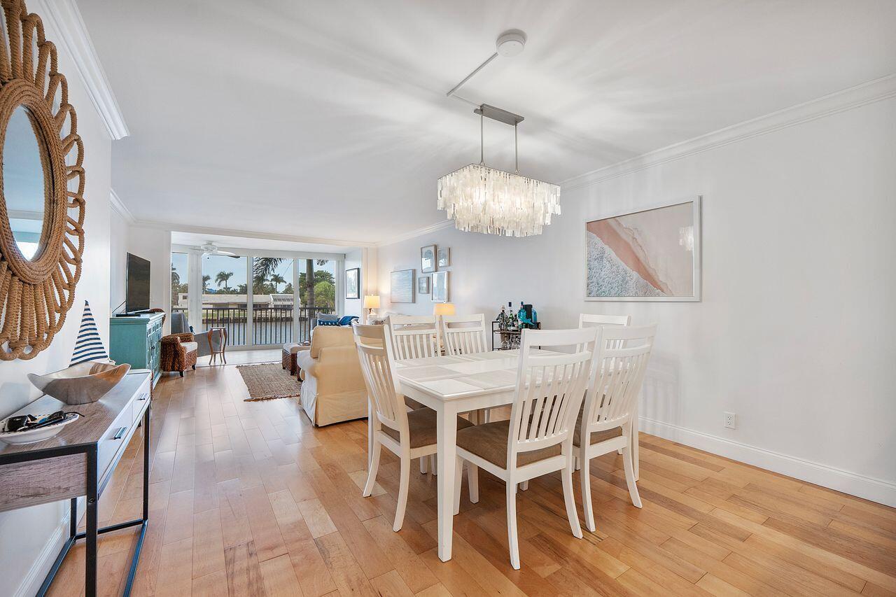 3310 South Ocean Boulevard, Unit 231D Highland Beach, FL 33487 - Photo 9 of 31 a view of a dining room with furniture wooden floor and chandelier