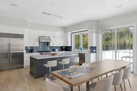 a kitchen with a stove a refrigerator a dining table and chairs