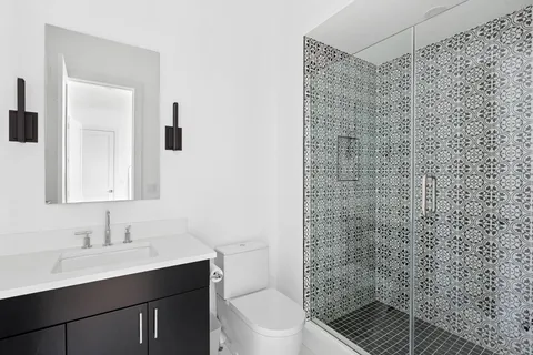 a bathroom with a sink a toilet and shower