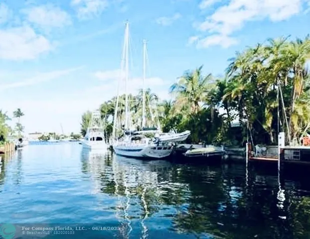 a view of lake with boats and trees in the background