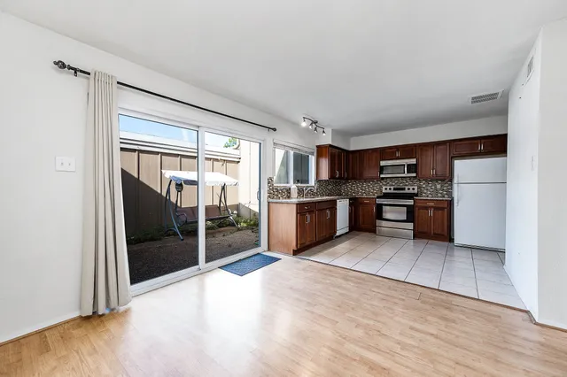 a large kitchen with stainless steel appliances granite countertop a refrigerator and a stove top oven