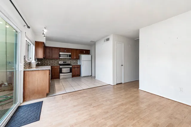a view of kitchen with stainless steel appliances cabinets