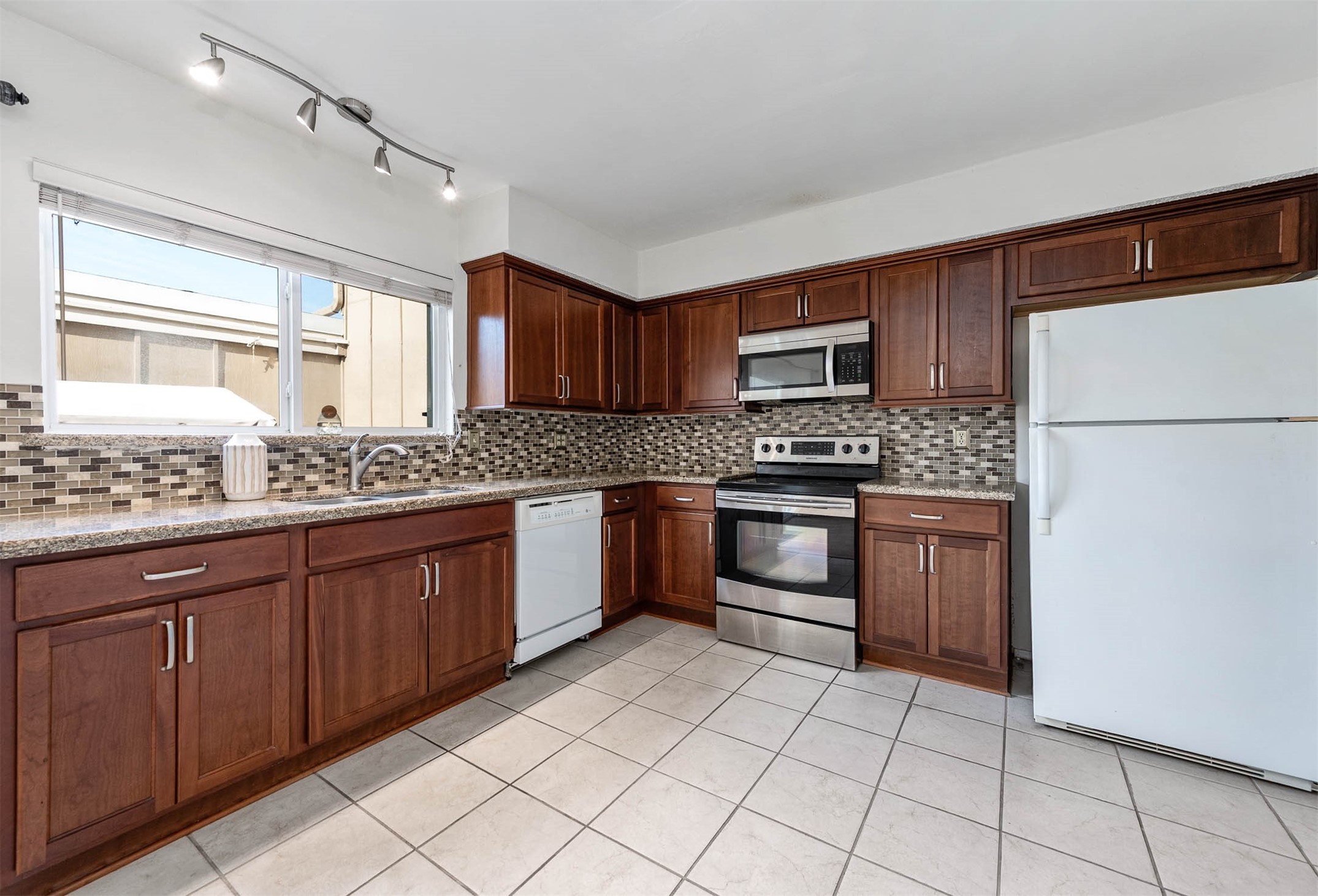11609 Village Pl Drive Houston, TX 77077 - Photo 16 of 34 a kitchen with granite countertop a sink stainless steel appliances and cabinets