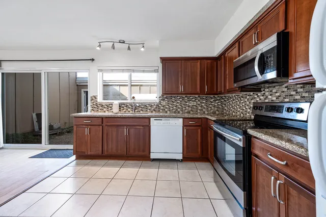 a kitchen with stainless steel appliances granite countertop a stove microwave and sink