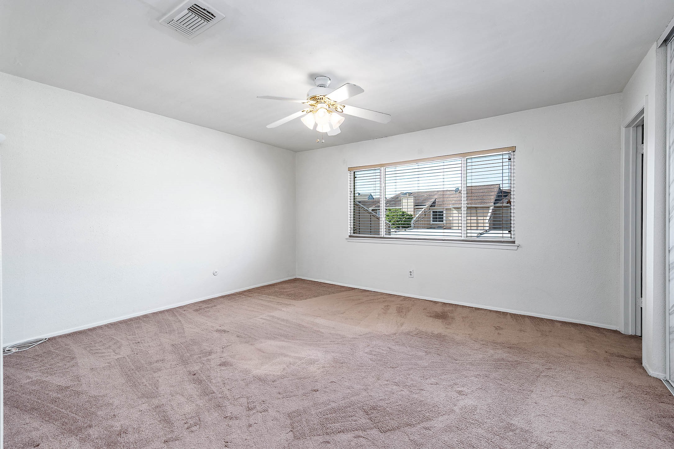 11609 Village Pl Drive Houston, TX 77077 - Photo 20 of 34 an empty room with windows and ceiling fan