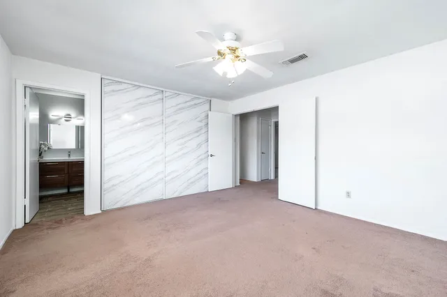 a view of an empty room with a ceiling fan