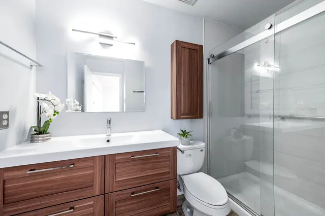 a bathroom with a sink a toilet and shower