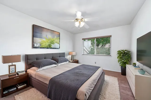 a bedroom with a large bed and a flat screen tv