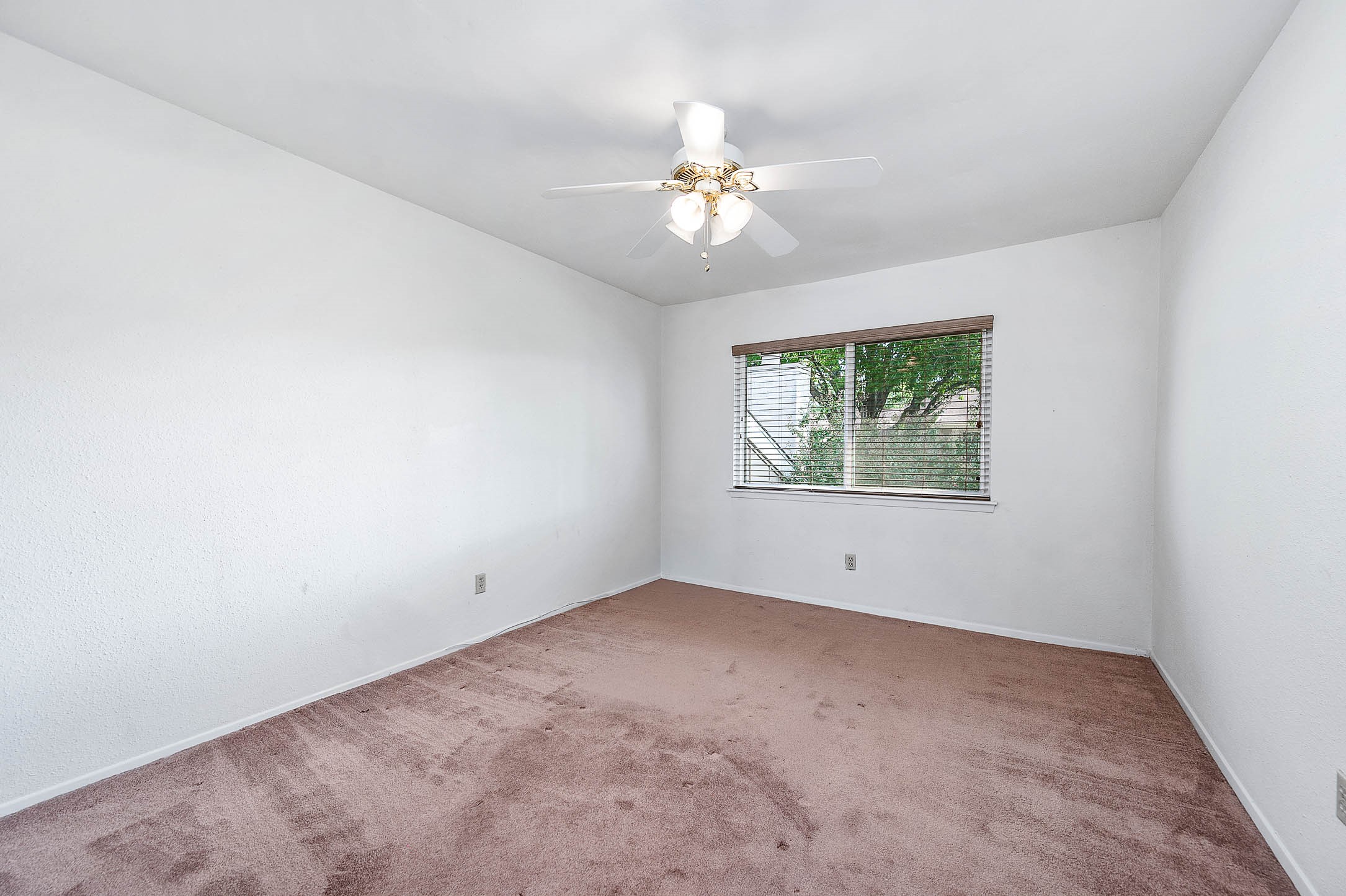 11609 Village Pl Drive Houston, TX 77077 - Photo 24 of 34 an empty room with chandelier fan and windows