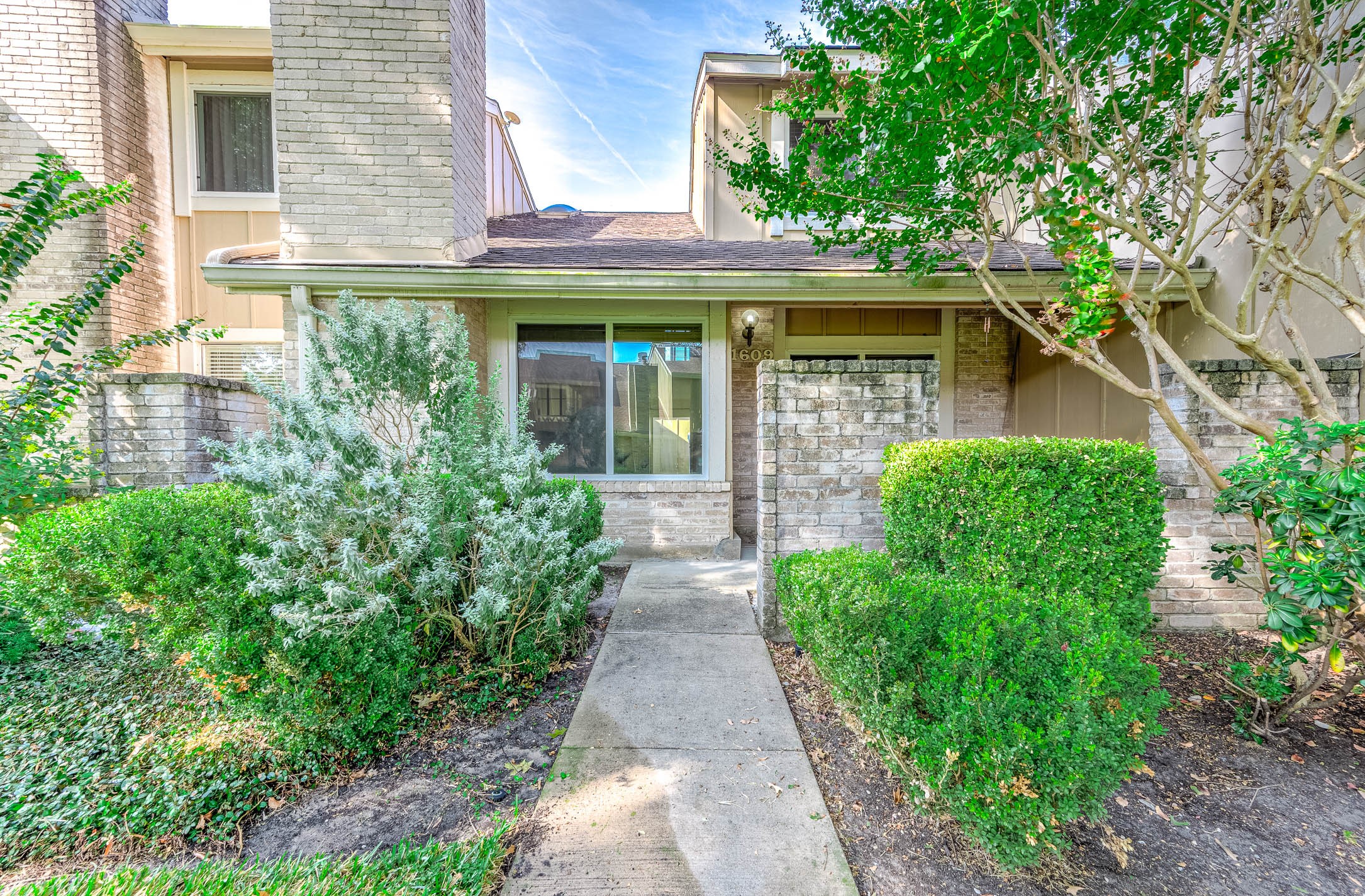 11609 Village Pl Drive Houston, TX 77077 - Photo 3 of 34 front view of a brick house with a small yard