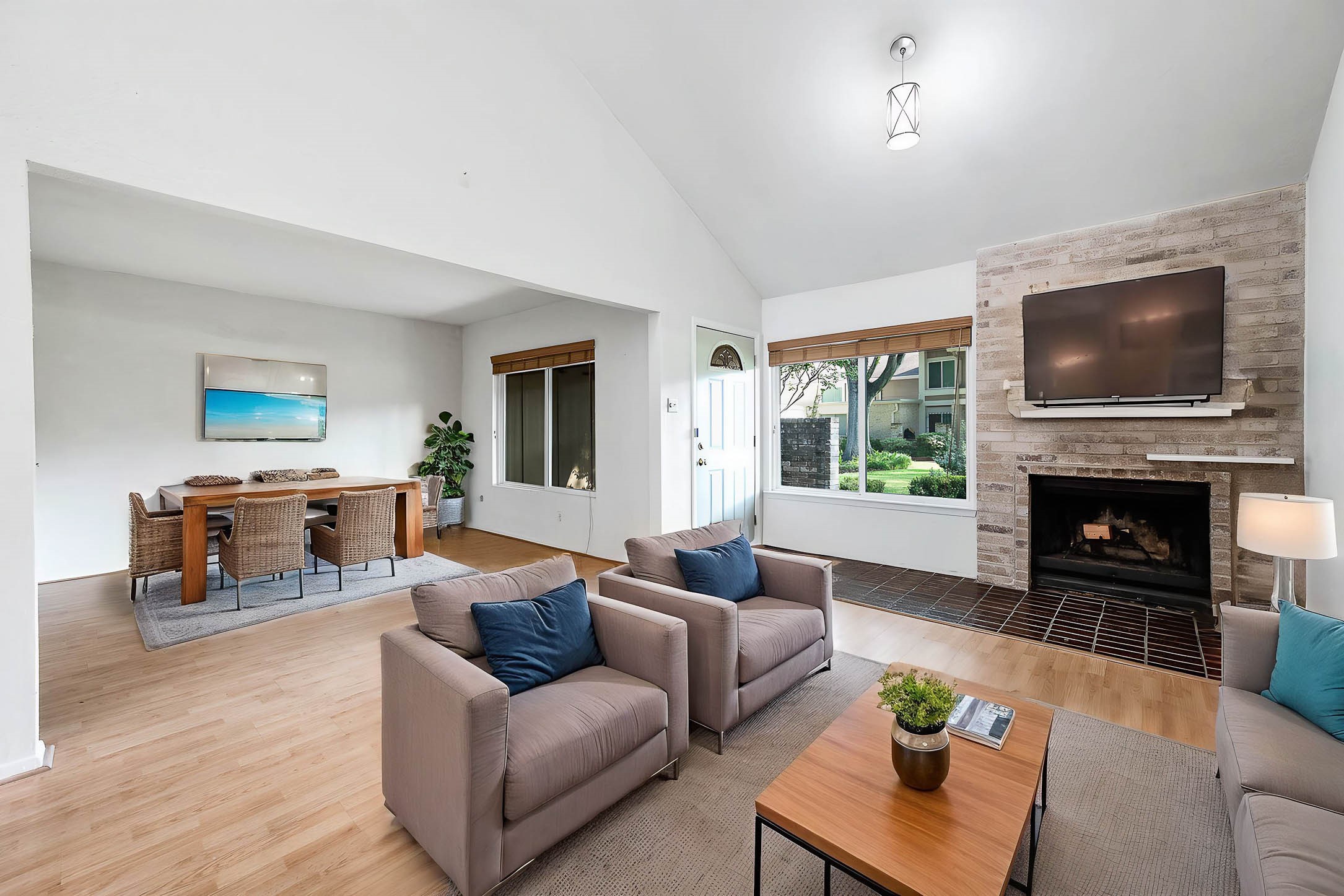 11609 Village Pl Drive Houston, TX 77077 - Photo 8 of 34 a living room with furniture a fireplace a flat screen tv and a large window