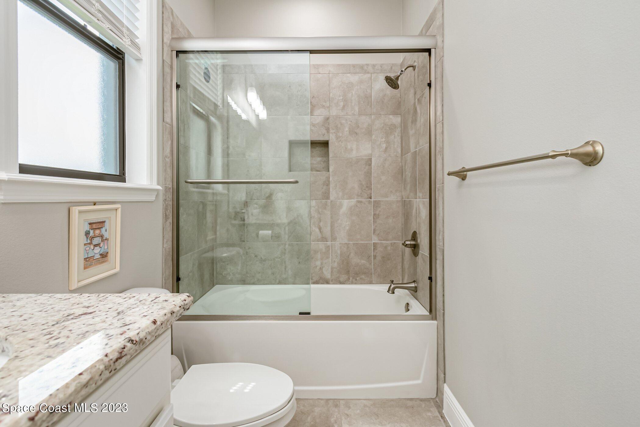 7729 Kerrington Drive Melbourne, FL 32940 - Photo 15 of 61 a bathroom with a granite countertop bathtub shower sink vanity and toilet