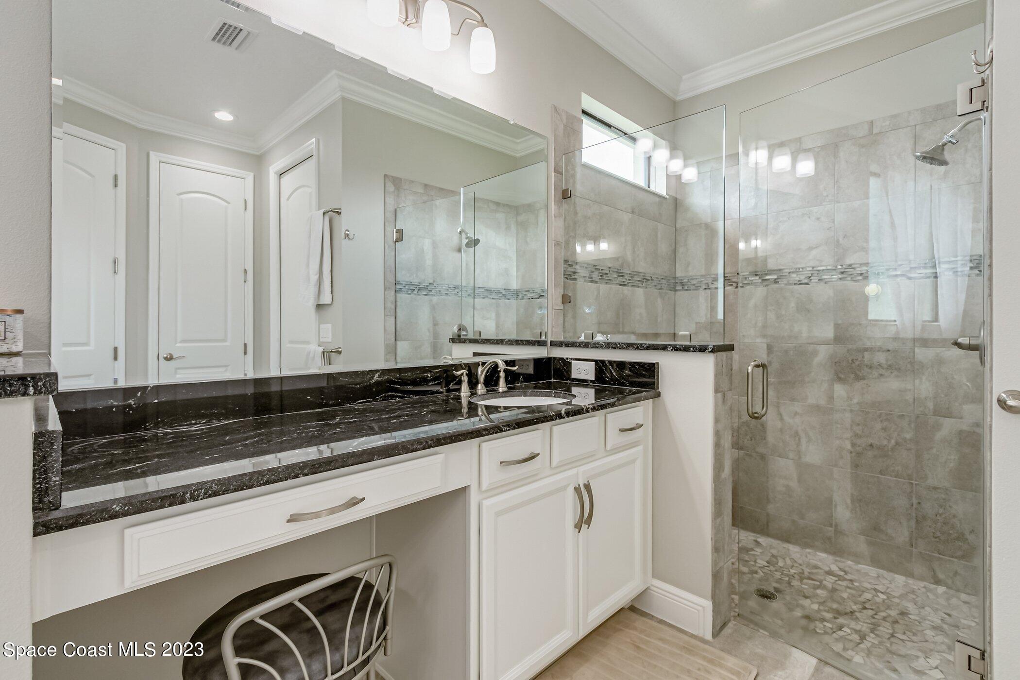 7729 Kerrington Drive Melbourne, FL 32940 - Photo 20 of 61 a bathroom with a granite countertop sink mirror and shower