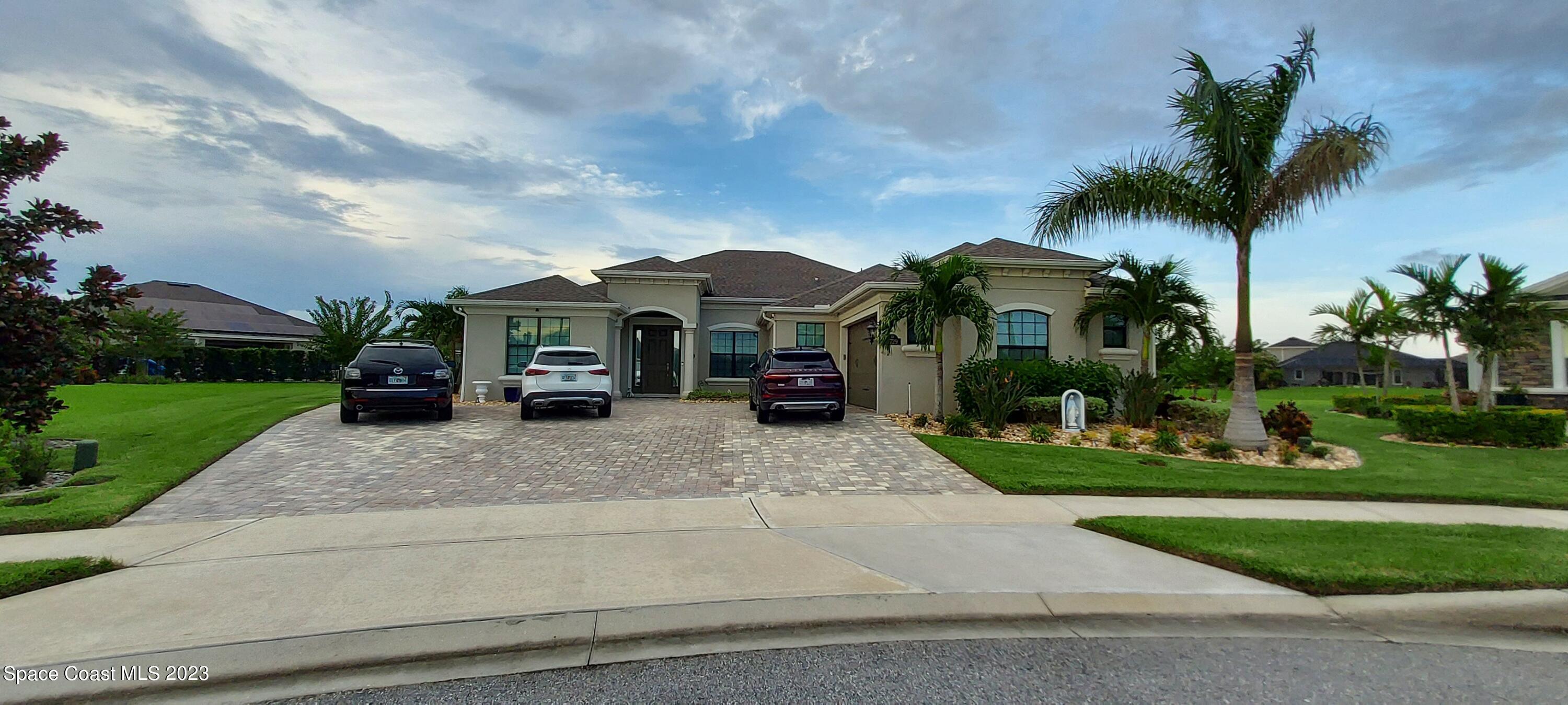 7729 Kerrington Drive Melbourne, FL 32940 - Photo 2 of 61 front view of a house with a yard and potted plants