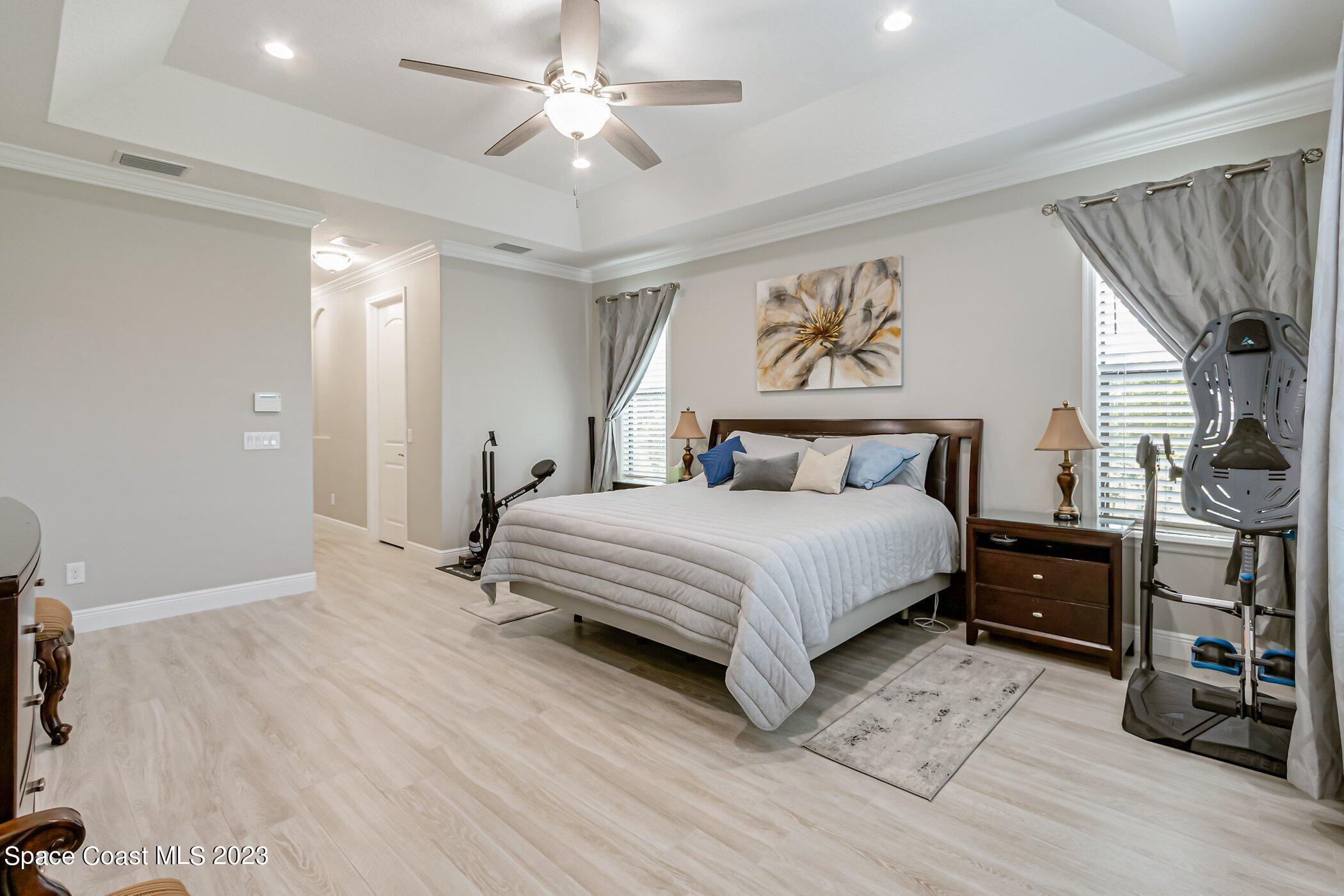 7729 Kerrington Drive Melbourne, FL 32940 - Photo 25 of 61 a bedroom with a large bed and a chandelier