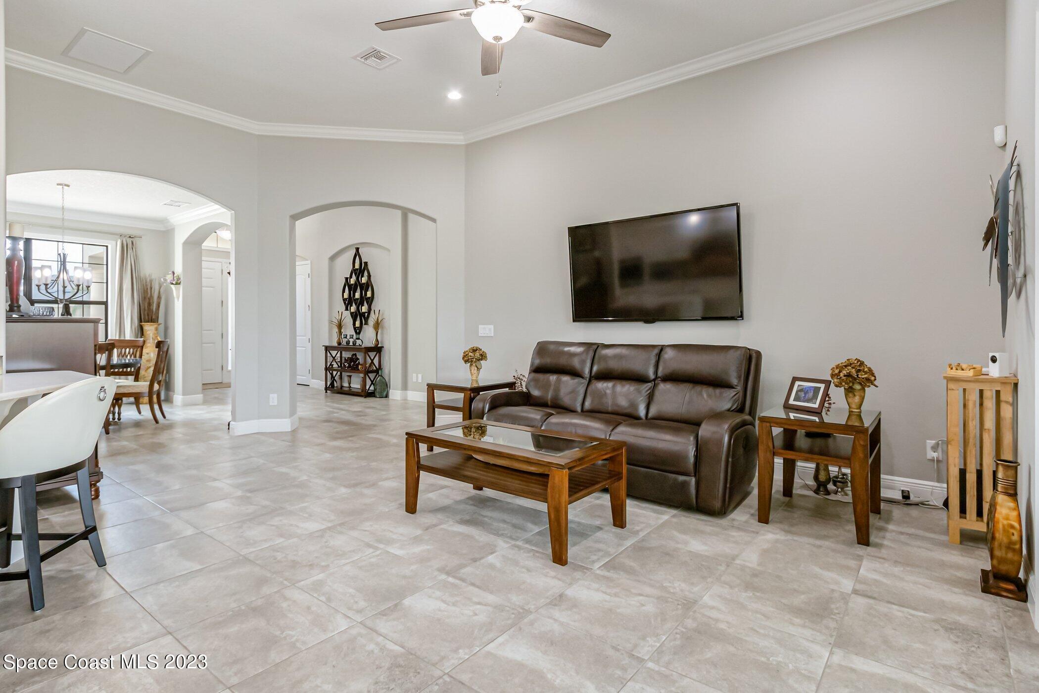 7729 Kerrington Drive Melbourne, FL 32940 - Photo 31 of 61 a living room with furniture and a flat screen tv