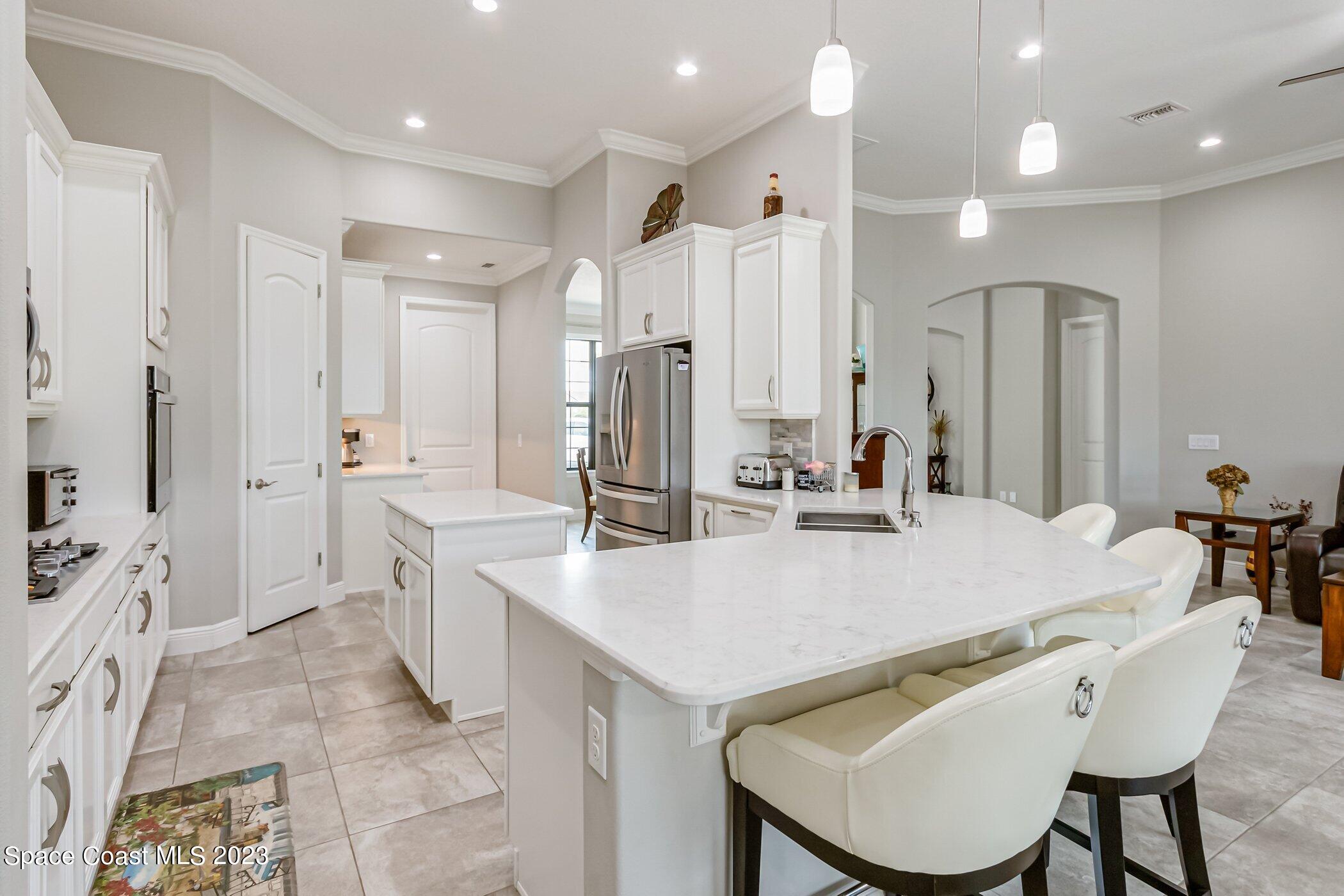 7729 Kerrington Drive Melbourne, FL 32940 - Photo 34 of 61 a large kitchen with kitchen island a sink table and chairs