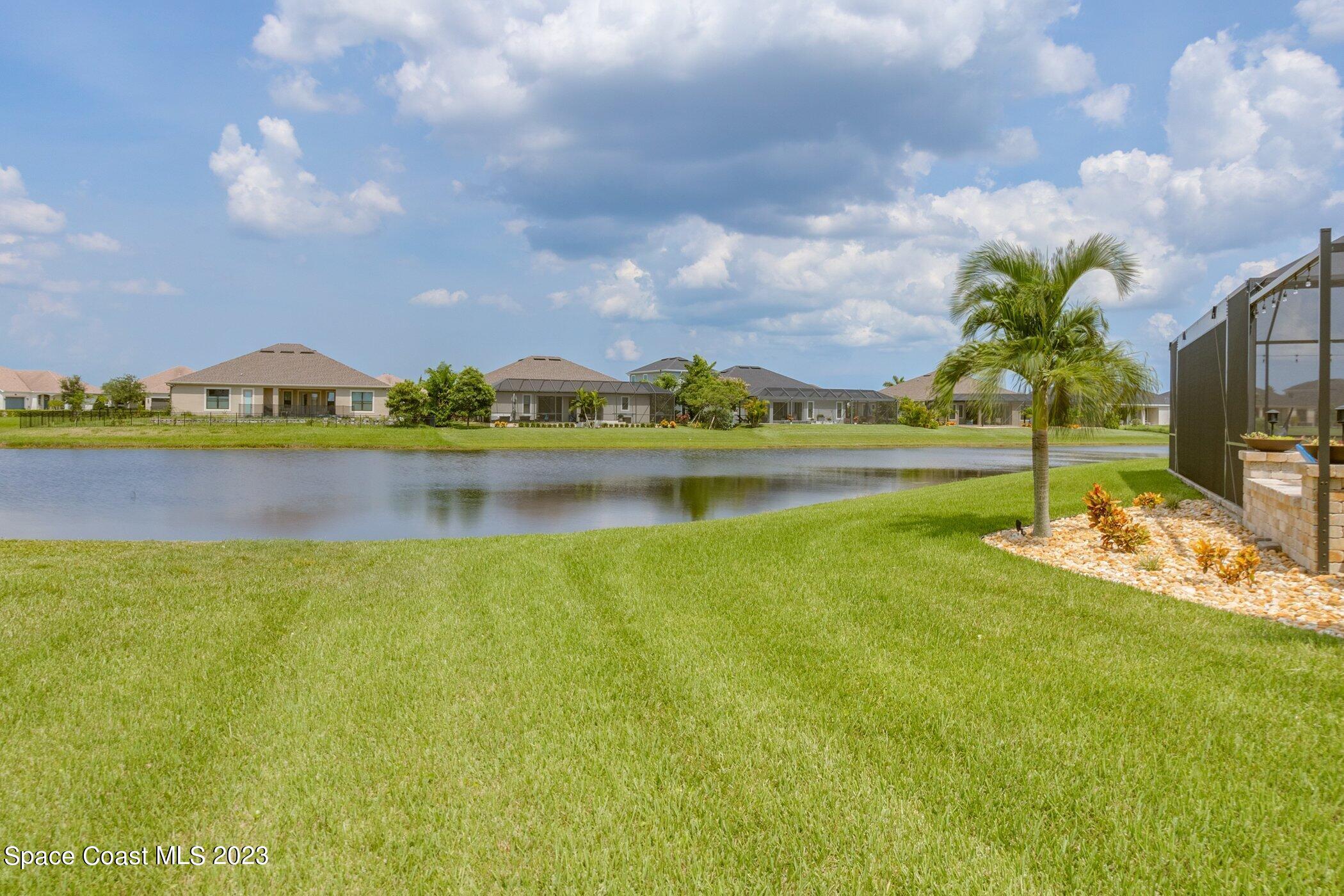 7729 Kerrington Drive Melbourne, FL 32940 - Photo 6 of 61 a view of a lake with houses in the back