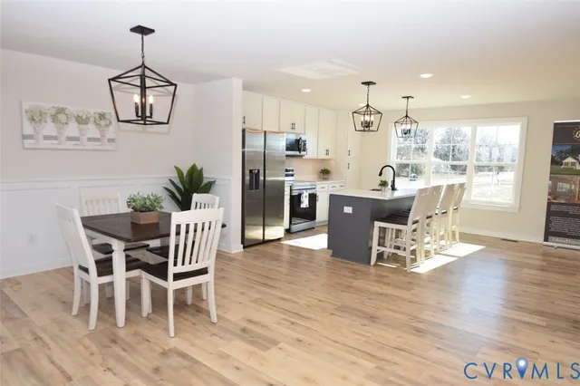 a dining room with furniture wooden floor a rug and a chandelier