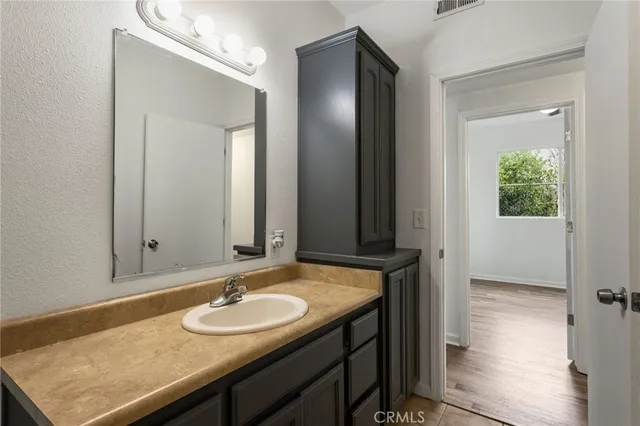 a bathroom with a granite countertop sink and a mirror