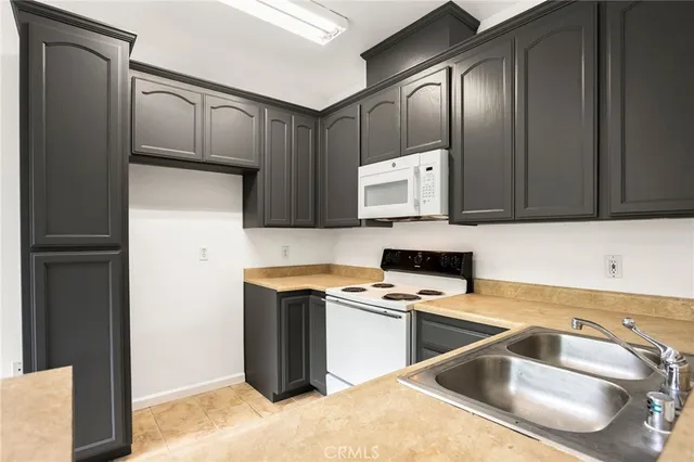a kitchen with a refrigerator sink and cabinets