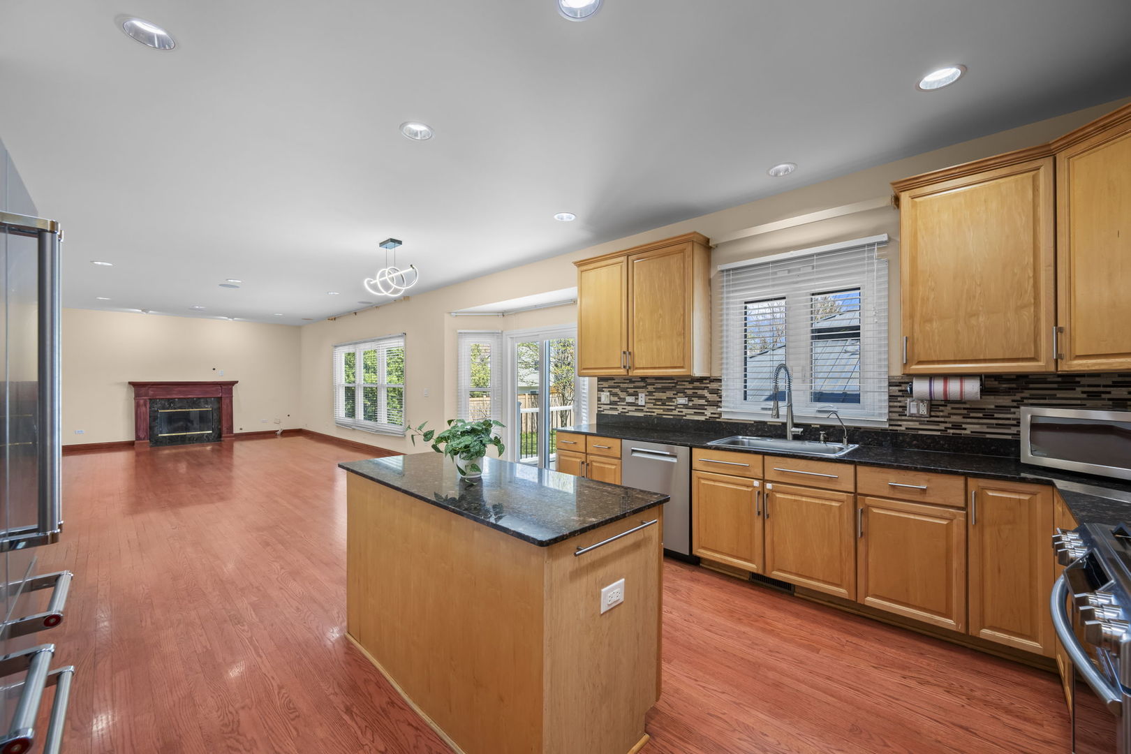 155 Lilac Lane Wheeling, IL 60090 - Photo 12 of 52 a kitchen with stainless steel appliances granite countertop wooden cabinets a stove a sink and a large window