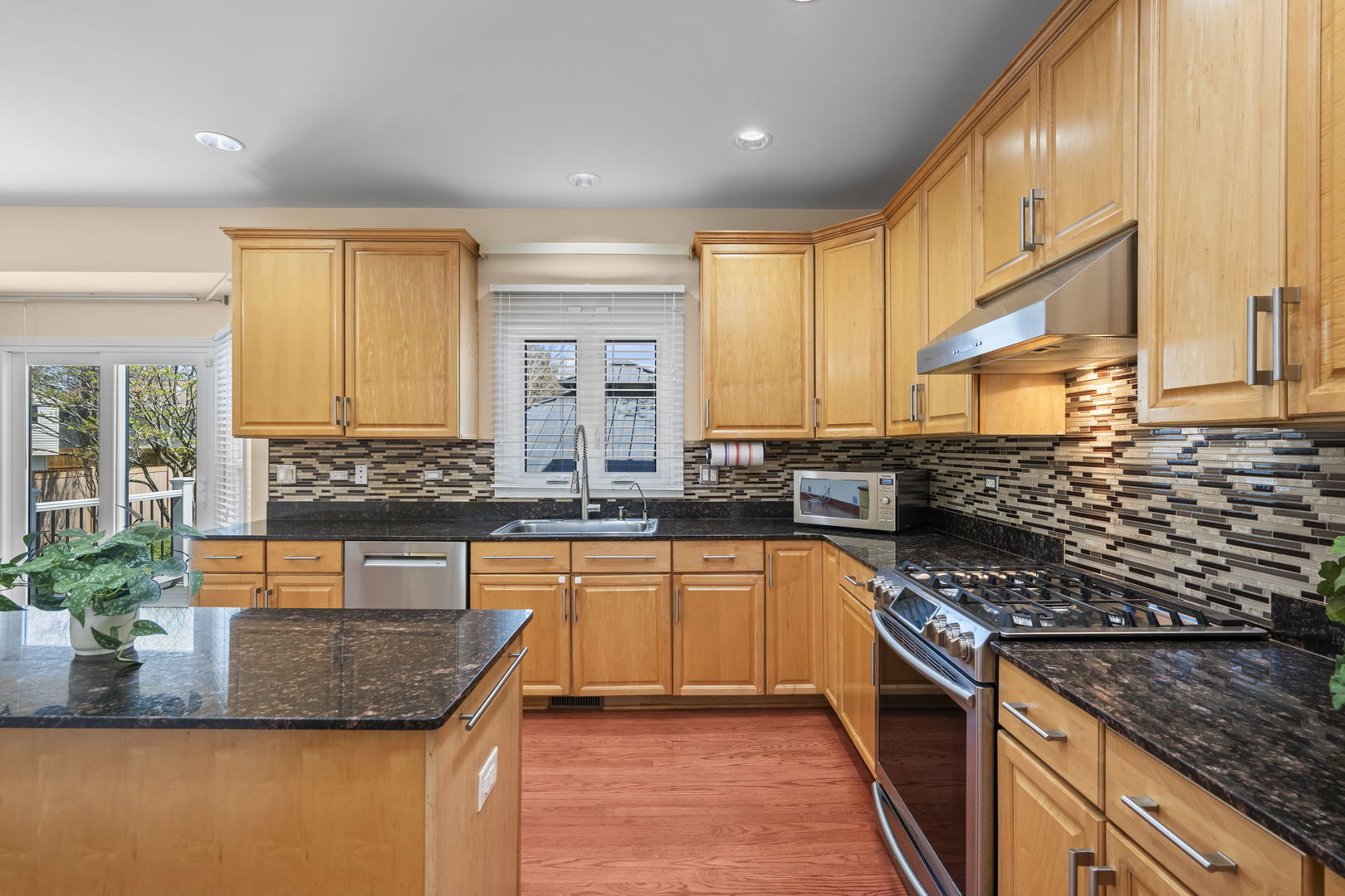 155 Lilac Lane Wheeling, IL 60090 - Photo 13 of 52 a kitchen with stainless steel appliances granite countertop a stove a sink and a microwave