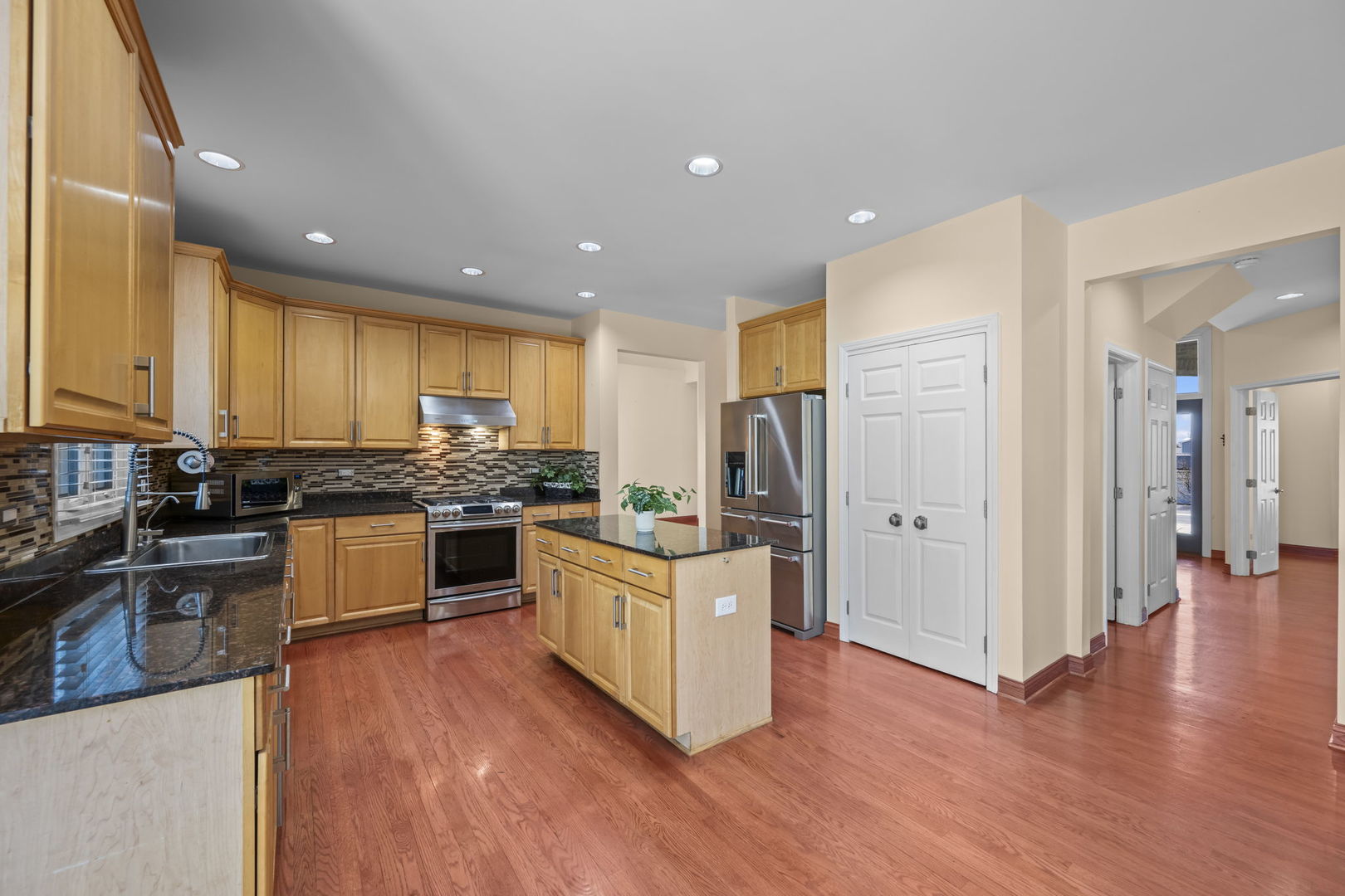 155 Lilac Lane Wheeling, IL 60090 - Photo 14 of 52 a kitchen with stainless steel appliances granite countertop a stove top oven a sink a refrigerator and white cabinets with wooden floor