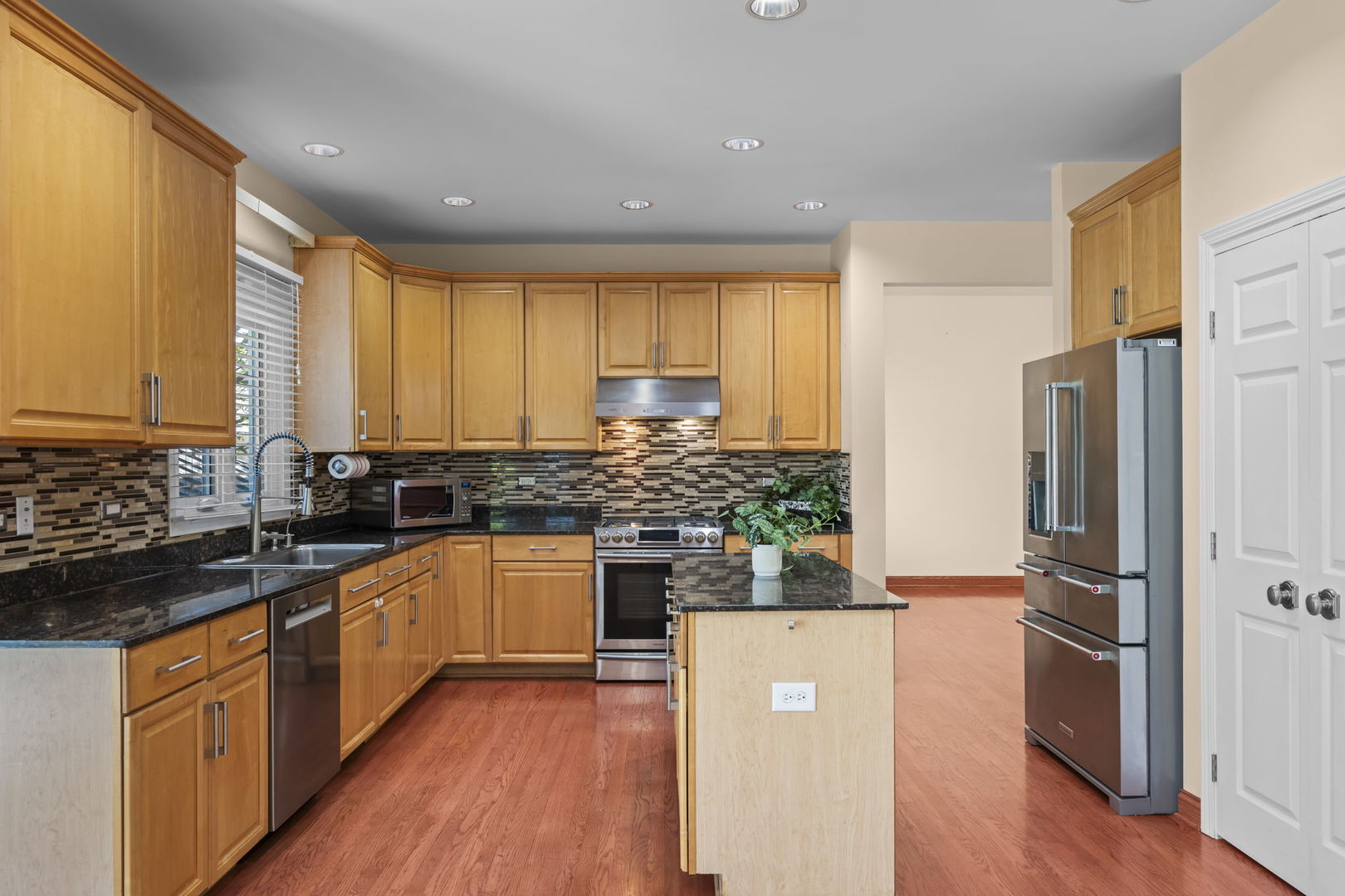 155 Lilac Lane Wheeling, IL 60090 - Photo 15 of 52 a kitchen with stainless steel appliances a refrigerator sink and wooden floor