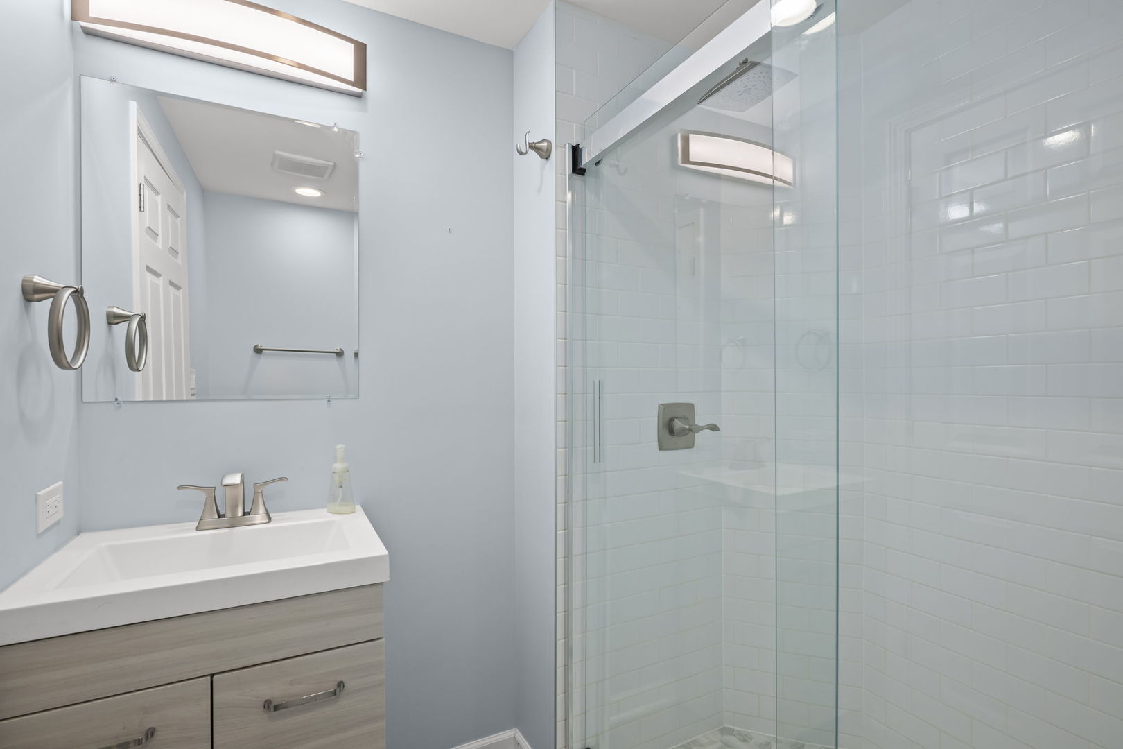 155 Lilac Lane Wheeling, IL 60090 - Photo 41 of 52 a bathroom with a sink a mirror a shower and vanity